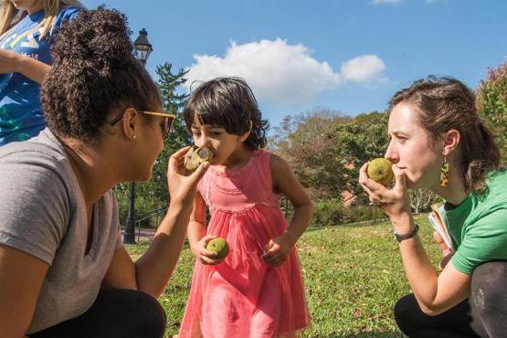 Two Ohio University students help a child during a community visit